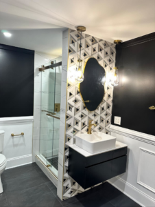 A completed modern bathroom renovation with a floating vanity and accent wall by Home Renovation & Design in Trumbull, CT.