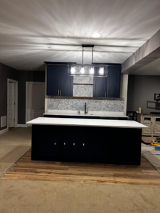 A beautifully completed modern kitchen remodel with dark cabinets and a white island by GD Home Remodeling in Annadale, VA.