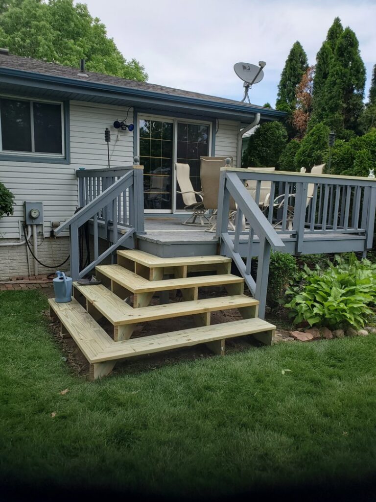 Newly completed wooden steps leading to an outdoor deck, a finished project by Folmar's Handyman & Remodeling in Lincoln, NE.