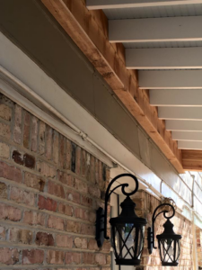 Completed outdoor ceiling with decorative lanterns on a brick wall by Felipe Garcia Remodeling and Construction in Mobile, AL.
