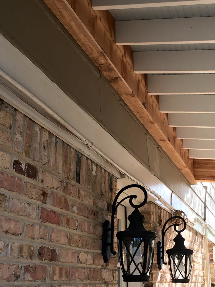 Completed outdoor ceiling with decorative lanterns on a brick wall by Felipe Garcia Remodeling and Construction in Mobile, AL.