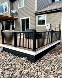 A newly completed outdoor deck with modern black railings by TNC Builders, LLC in Aurora, CO