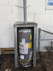 A completed outdoor water heater installation with a vent pipe by High Tide Home Remodeling in Charleston, SC.