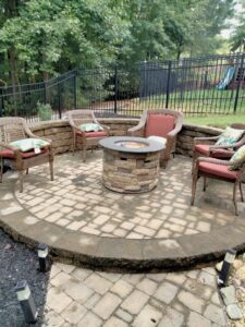 A beautifully completed patio with a stone fire pit and seating, built by Mels Haul & Junk Removal in Raleigh, NC.