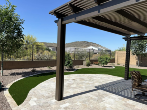 A completed brown pergola and paver patio with artificial turf installed by Az Sun Covers in Surprise, AZ.