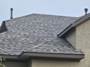 A close-up of a newly completed residential roof with multi-colored shingles and vents, showcasing work by APEX Roofing in Georgetown, TX.
