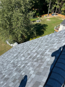 A completed residential roof with gray shingles and a green backyard view, by New American General Construction INC in Richmond, VA.