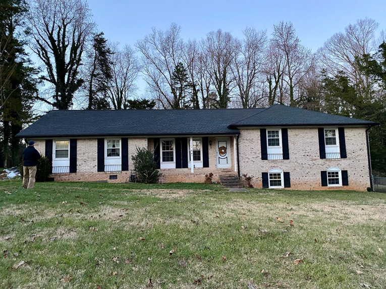 A residential house with a newly installed dark roof by First Class Roofing Inc. in High Point, NC