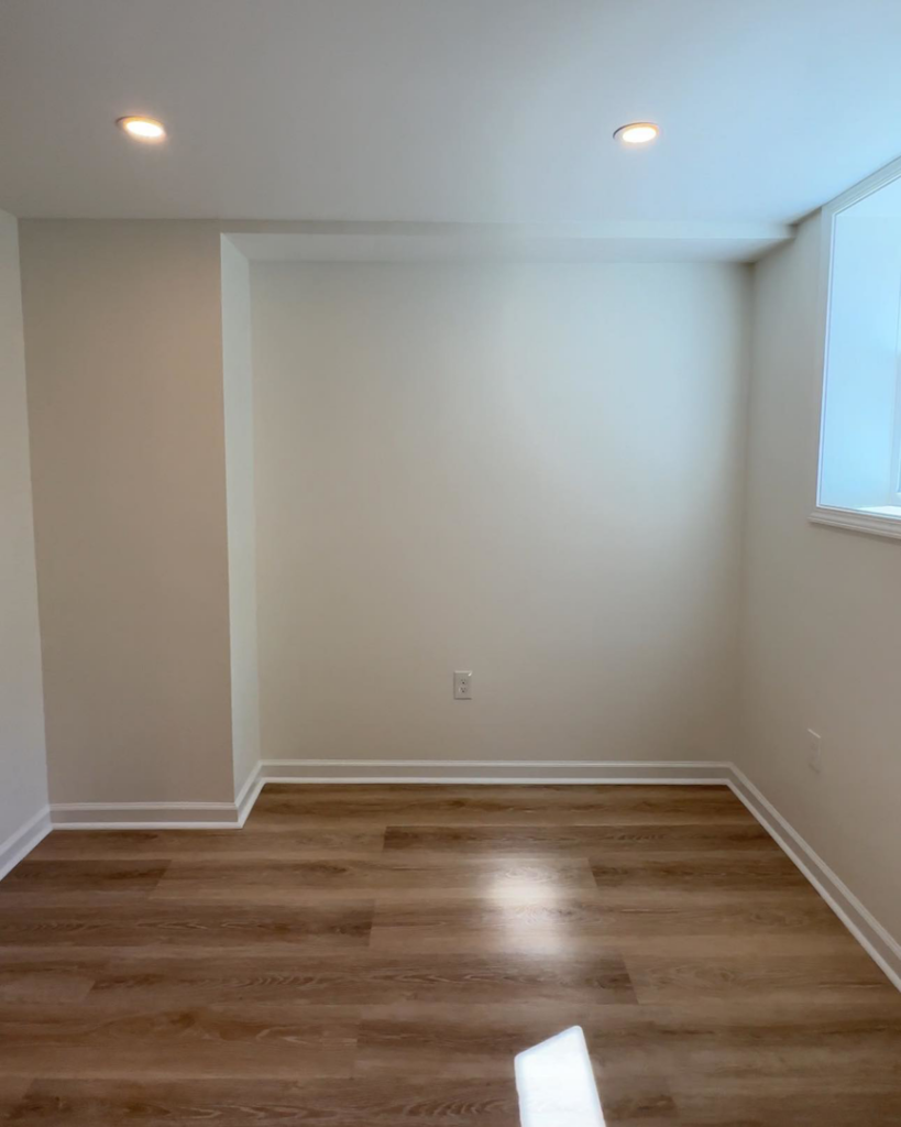 A completed room renovation with new hardwood floors and fresh walls, performed by Under The Wire Renovations in Atlanta, GA.