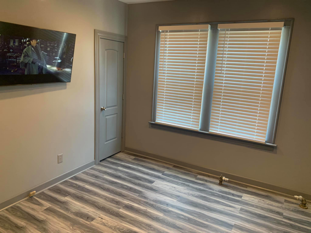 A completed room renovation featuring new flooring, painted walls, and window blinds by UpGray'D Remodeling LLC in Chicago, IL