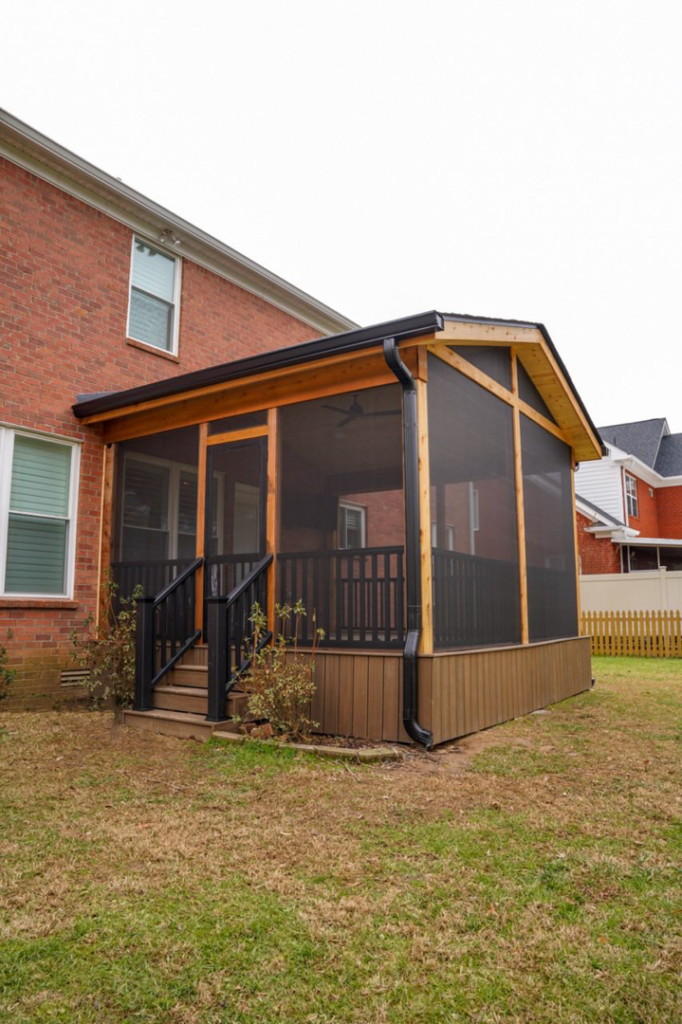 Exterior view of a beautifully completed screened porch attached to a brick house by Vision Construction in Framingham, MA.
