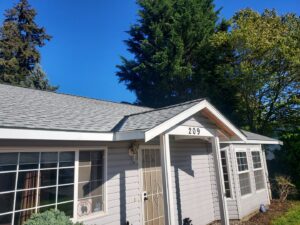 A newly completed shingle roof on a grey house by Sunny's roofing LLC in Denver, CO.