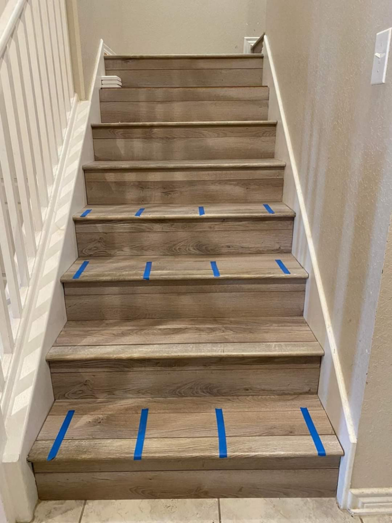 A newly completed staircase flooring project with wood-look planks by DeLeon Contracting LLC in San Antonio, TX.
