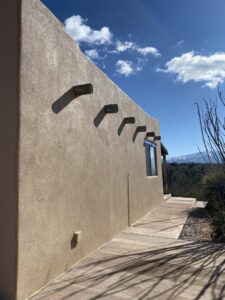 A beautifully completed stucco wall with decorative wooden beams by Old Pueblo Stucco, Inc. in Tucson, AZ
