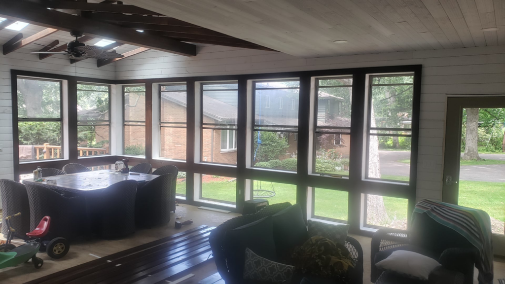 A beautifully completed sunroom addition interior with large windows and a ceiling fan by Ironside Home Improvements, LLC in Madison, WI.