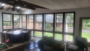 A beautifully completed sunroom addition interior with large windows and a ceiling fan by Ironside Home Improvements, LLC in Madison, WI.