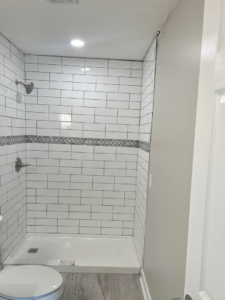 A beautifully completed tiled shower with modern fixtures, part of a bathroom remodel by Gardner Home Services in Pleasant Grove, AL.