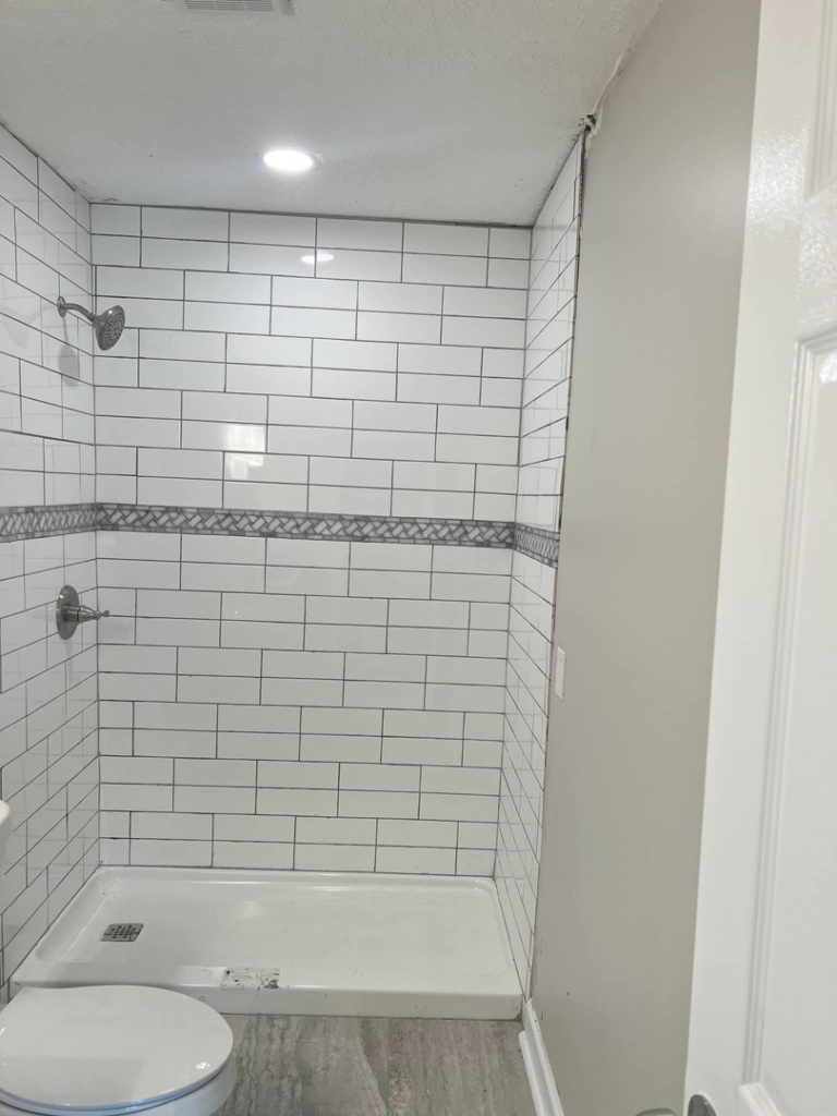 A beautifully completed tiled shower with modern fixtures, part of a bathroom remodel by Gardner Home Services in Pleasant Grove, AL.