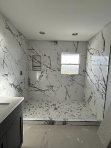 A completed tiled shower with a unique pebble floor by Gregg Hoffman Construction Inc. in Tacoma, WA