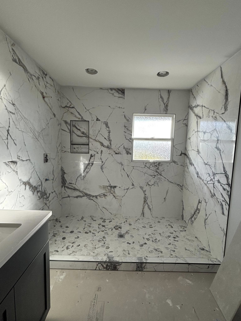 A completed tiled shower with a unique pebble floor by Gregg Hoffman Construction Inc. in Tacoma, WA