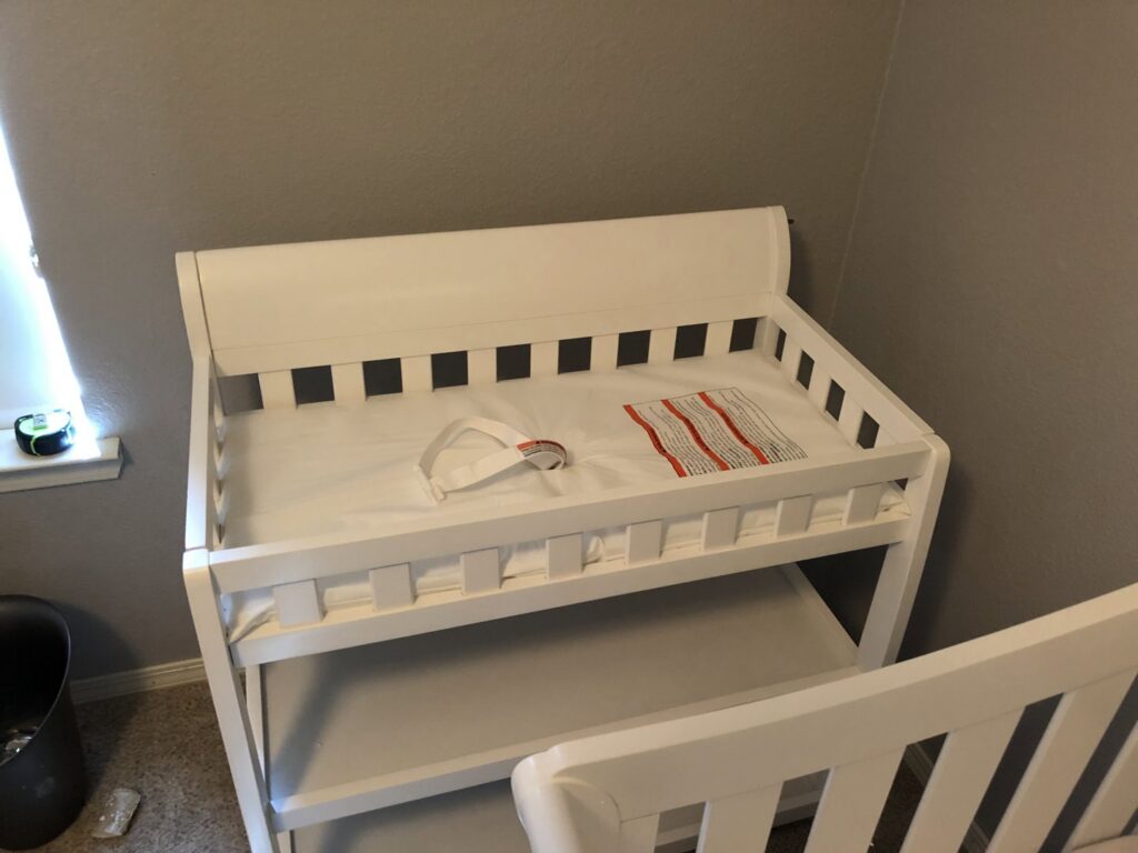 A fully assembled white baby changing table with a changing pad, showcasing completed furniture assembly by The ABQ Handyman in Albuquerque, NM.