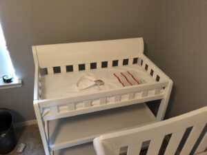 A fully assembled white baby changing table with a changing pad, showcasing completed furniture assembly by The ABQ Handyman in Albuquerque, NM.