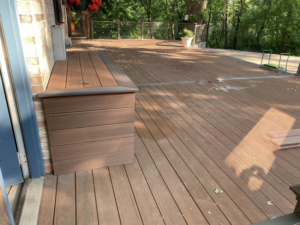 A spacious, newly completed wooden deck with a built-in storage bench, constructed by Building Arts by Jimmy Z in Cassville, WI.