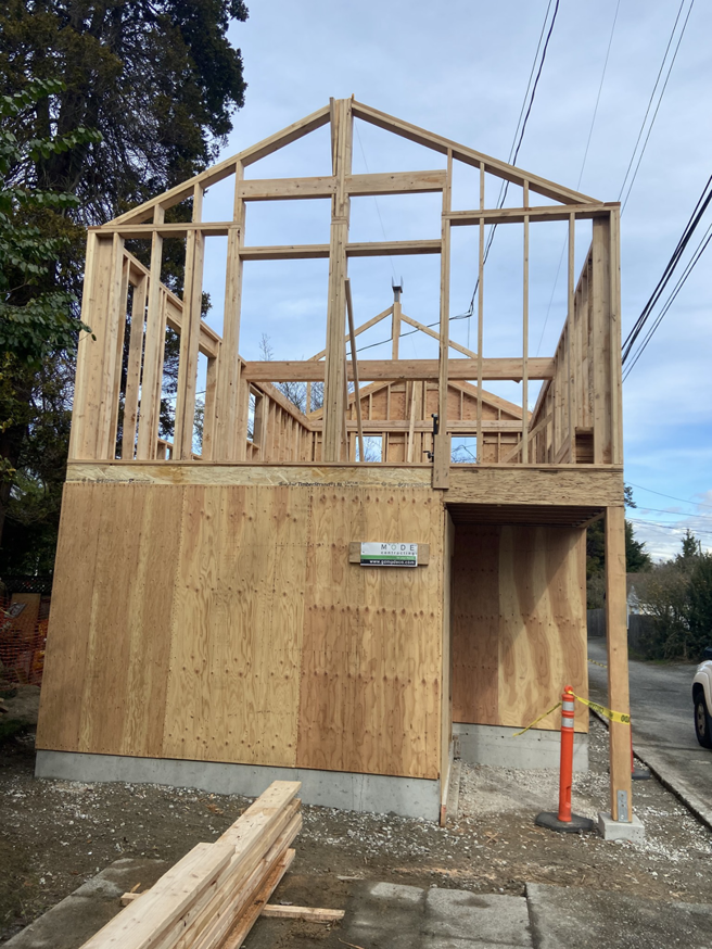 A completed wood-framed structure with partial sheathing, showcasing work by Mode Contracting in Seattle, WA.