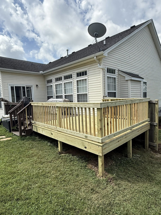 A completed wooden backyard deck with railings attached to a house by Mr. GreenJeans in Indianapolis, IN.