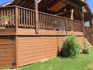 A beautifully completed large wooden deck with railings and a pergola, built by Savala's Remodeling Services in Austin, TX.