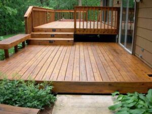 A completed wooden deck with a built-in bench and steps by Prenga Remodeling in Orange, CT