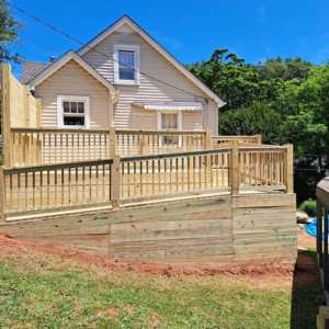 A completed wooden deck and ramp with a retaining wall built by Vest Home Services LLC in Greenville, SC.