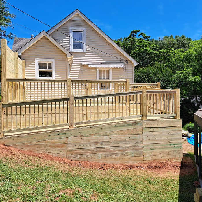 A completed wooden deck and ramp with a retaining wall built by Vest Home Services LLC in Greenville, SC.