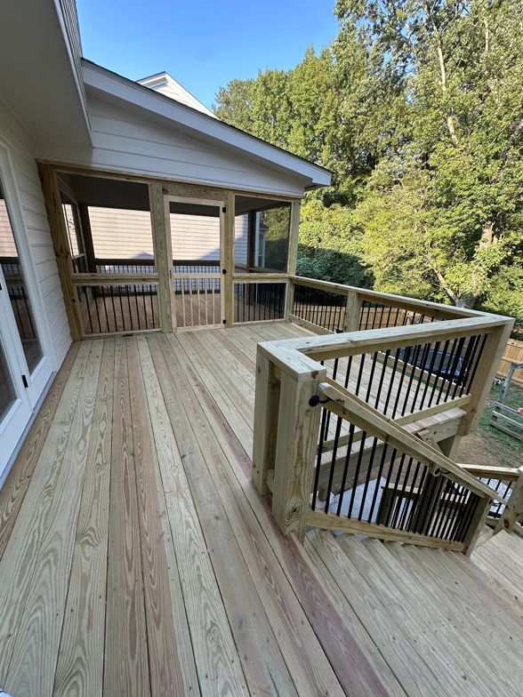 A completed wooden deck and screened porch attached to a house by Housworth Construction in Suwanee, GA