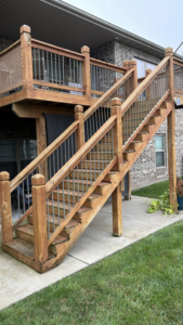A beautifully maintained wooden deck with stairs leading to a lawn, showcasing completed work by HW Handyman Services in Springfield, MO.