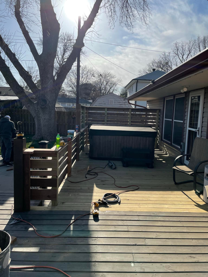 A newly completed wooden deck with a hot tub and railing, built by B&B Handyman Solutions in Omaha, NE.