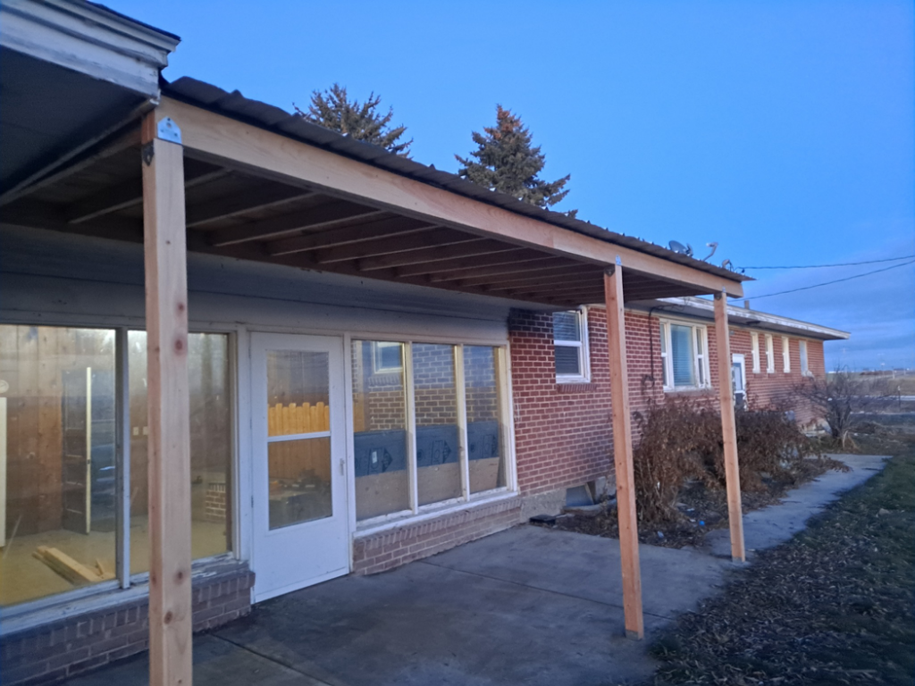 A newly completed wooden patio cover with a roof, built by Honey Don'ts Handyman Service in Twin Falls, ID.
