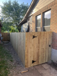 A completed wooden privacy fence with a gate, showcasing the general contracting services of Triple A' Construction in San Antonio, TX.
