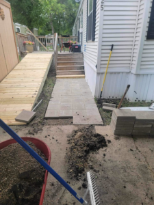 A newly completed wooden ramp and a partially paved pathway with pavers, showcasing work by Becker Services ND in West Fargo, ND.