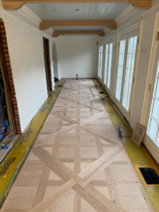 Installation of a complex pattern hardwood floor in a hallway by Heritage Floors of Hanover LLC in Mechanicsville, VA.