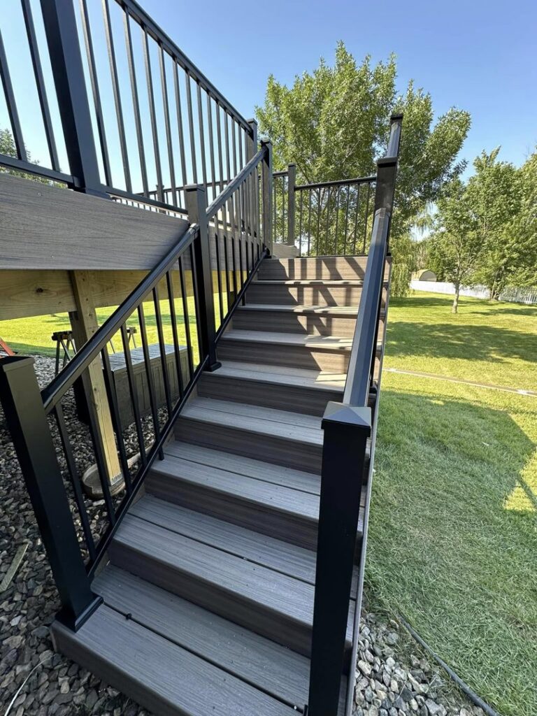 Durable composite deck stairs with sleek black metal railings, installed by Watertown Handyman in Watertown, SD.