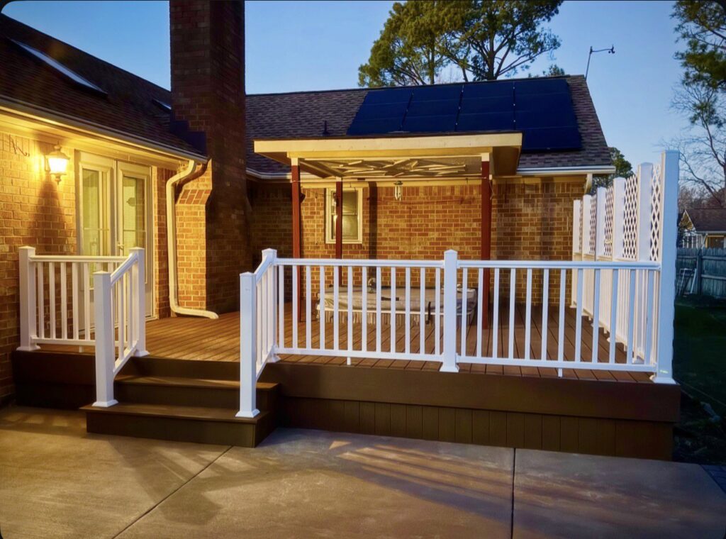 Newly installed composite deck with white railings and a privacy screen by BOS HOME Exterior Services in Virginia Beach, VA