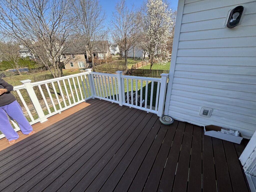 A finished deck featuring durable composite decking and clean white railings, built by McIntosh Construction in Des Peres, MO.