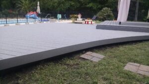 A spacious composite deck installed next to a swimming pool by Pro Renovations Savannah, GA.