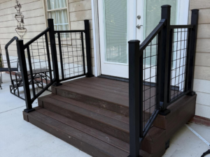 Custom composite steps with black metal grid railings leading to an entrance, installed by HoBart Builders, Inc. in Columbus, GA.