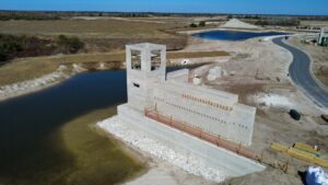 Construction of a large concrete block structure next to a body of water, part of a general contracting project by Bayside Concrete & Construction in Tampa, FL