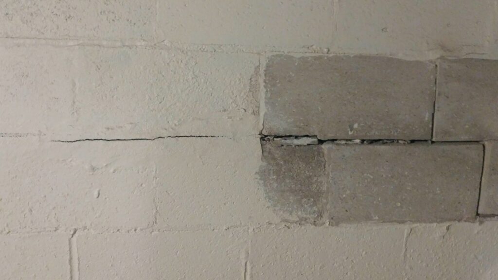 A horizontal crack in a concrete block wall, showing damage E.S. Leonard Waterproofing can repair in De Soto, MO.