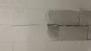 A horizontal crack in a concrete block wall, showing damage E.S. Leonard Waterproofing can repair in De Soto, MO.