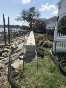 A concrete block retaining wall constructed along a waterfront by Solimini Excavation and Utility in Freetown, MA