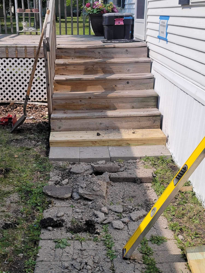 Concrete demolition and step repair preparation at the base of wooden stairs, performed by Becker Services ND in West Fargo, ND.